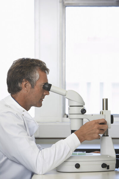 Male lab worker with microscope