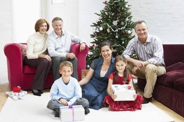 家人坐在圣诞树上 — 图库照片