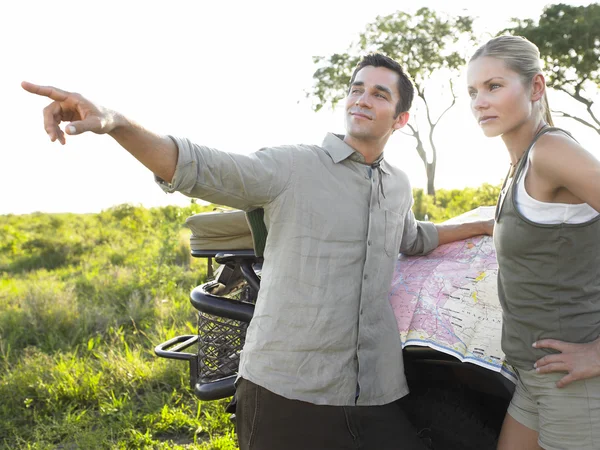 Man pointing map on jeep