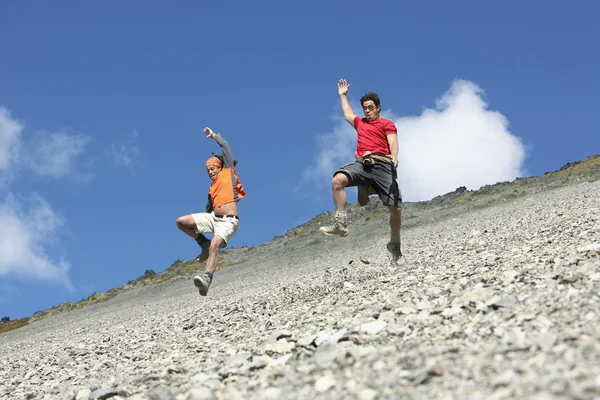 Zwei Männer springen über Bildschirmfeld — Stockfoto