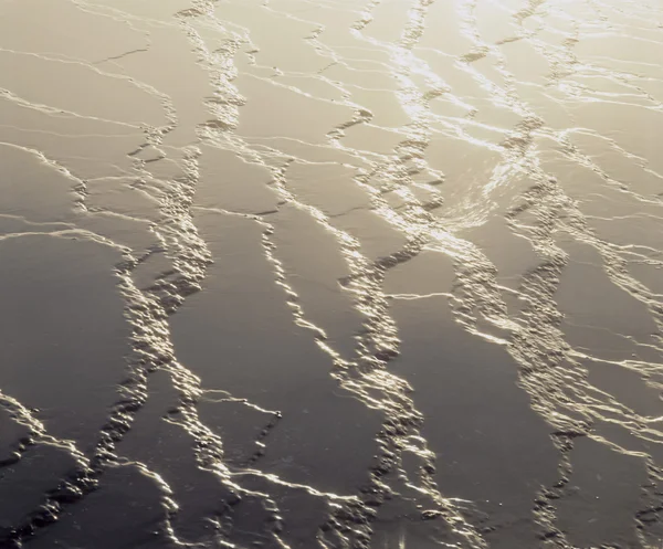 Islak kum üzerinde güneş ışığı — Stok fotoğraf
