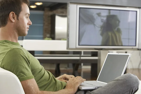 Homem usando laptop no sofá — Fotografia de Stock