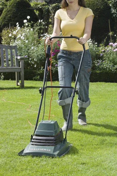 Vrouw met grasmaaier — Stockfoto