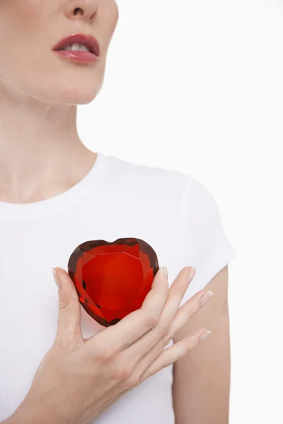 Woman holding heart-shaped jewel — Stock Photo, Image