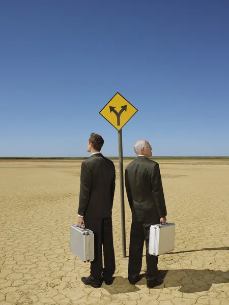 Businessmen standing by  sign — Stock Photo, Image