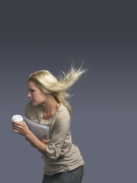 Mulher com cabelo soprando segurando café — Fotografia de Stock