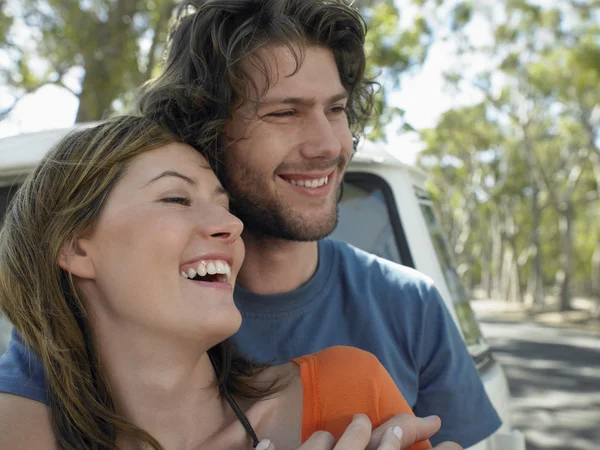 Couple embracing leaning against front of van — Stock Photo, Image