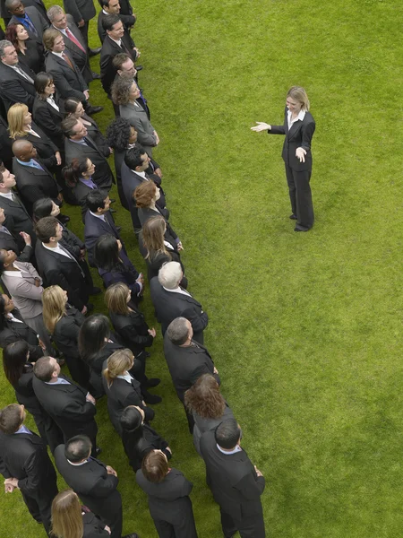 Business woman facing large group of people — Stock Photo, Image