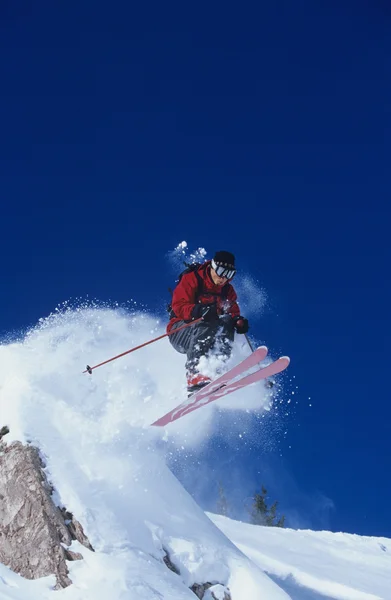 Skifahrer springt von Felsvorsprung — Stockfoto