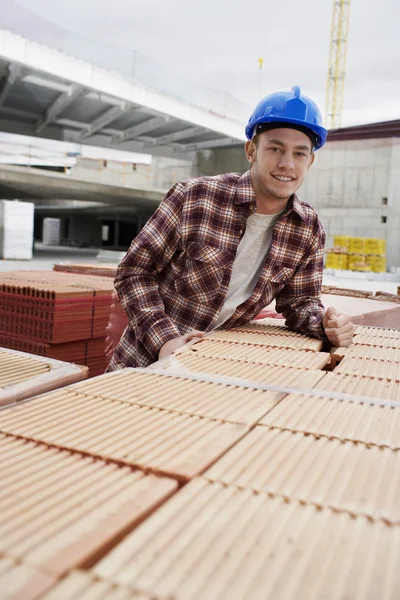 Trabajador de la construcción apoyado en baldosas — Foto de Stock