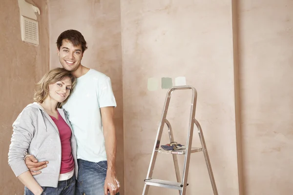 Couple embracing in unrenovated room — Stock Photo, Image