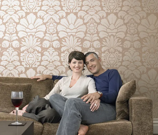 Smiling couple relaxing on sofa — Stock Photo, Image