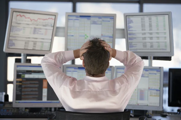 Businessman watching computer screens — Stock Photo, Image