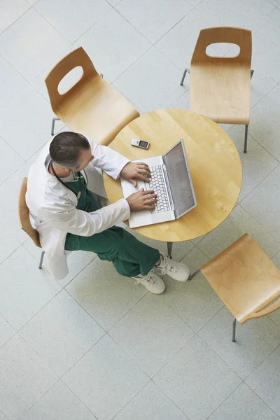 Arts met behulp van laptop in cafetaria — Stockfoto
