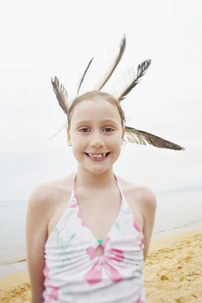 Dívka na pláži s peřím na vlasy — Stock fotografie