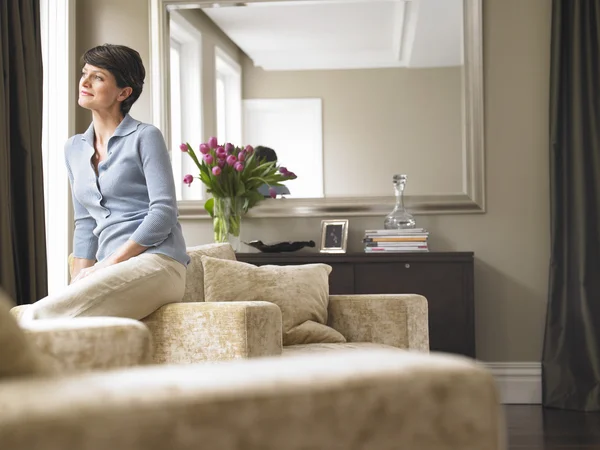 Mujer mirando por la ventana — Foto de Stock