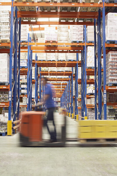 Man Driving Pallet Jack Through Warehouse