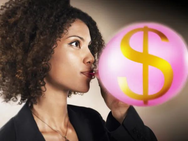Businesswoman Blowing Money Bubble