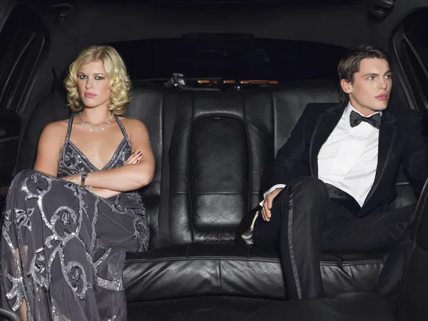 Couple in evening wear in back of car — Stock Photo, Image