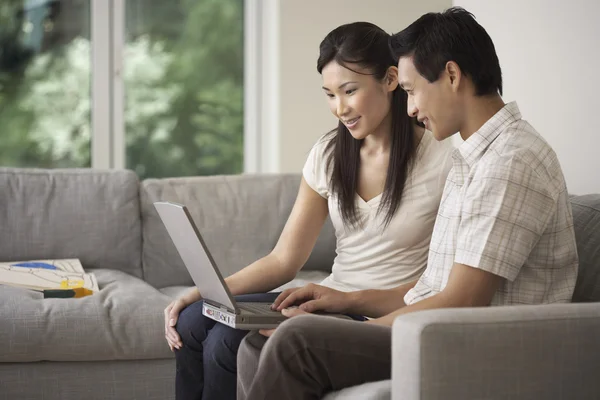 Koppel op sofa met behulp van een laptop — Stockfoto