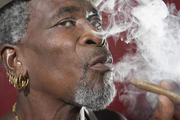 Afrykański mężczyzna wydech cygaro dym — Zdjęcie stockowe