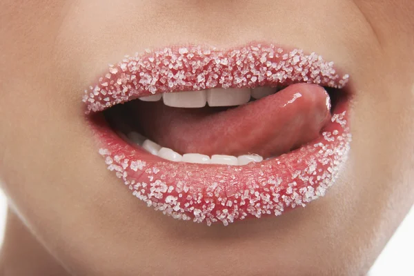 Tongue licking lips covered in sugar — Stock Photo, Image