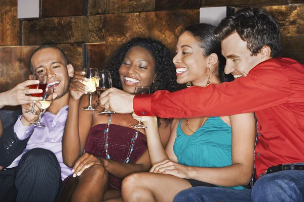 Группа друзей пьет тост, сидя в баре — стоковое фото