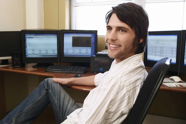 Joven hombre de negocios con computadoras — Foto de Stock
