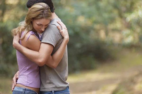 Pareja abrazándose en el bosque — Foto de Stock