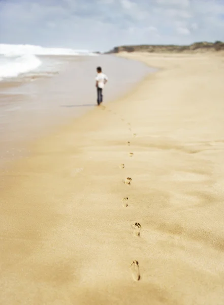Мальчик прогуливается вдоль песчаного пляжа — стоковое фото