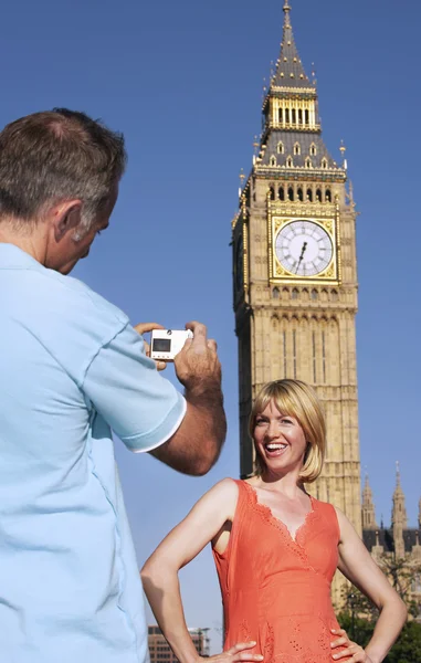 Echtgenoot nemen foto van vrouw door de big ben toren — Stockfoto