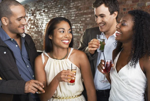 Two couples holding drinks standing in bar Royalty Free Stock Images