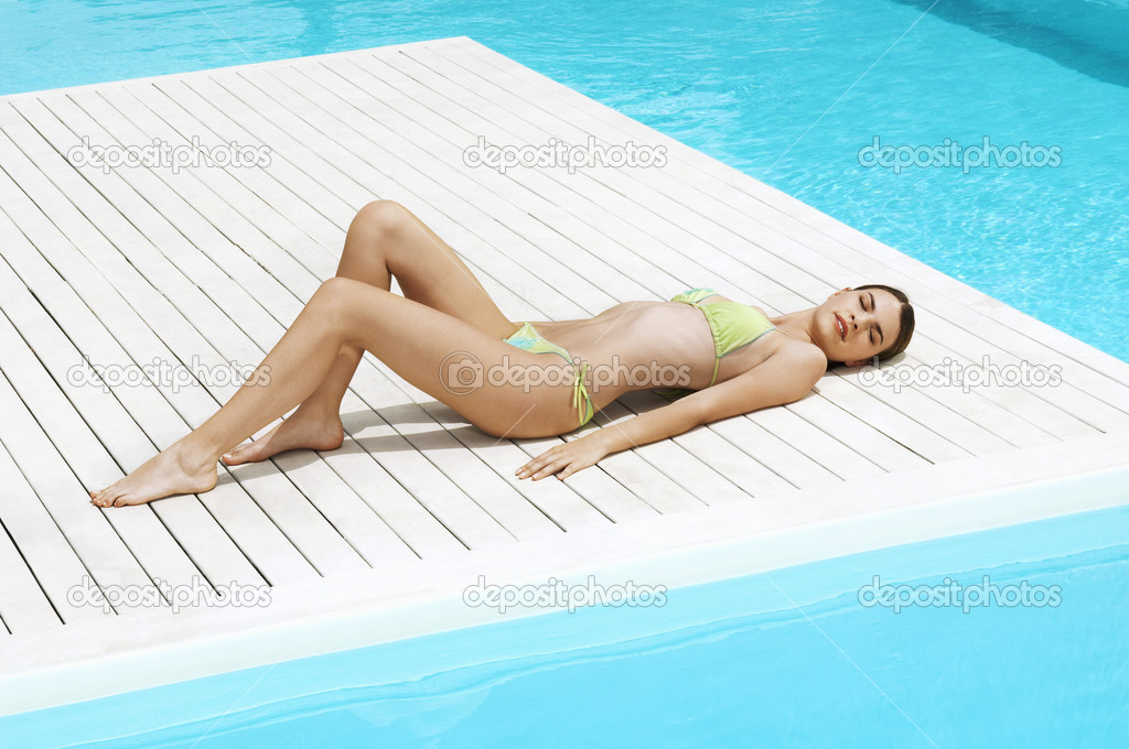 Woman Sunbathing by swimming pool