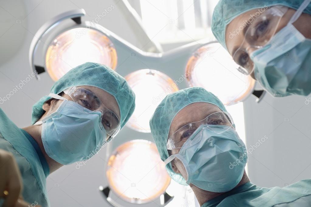 Surgeons preparing to operate in operating theatre