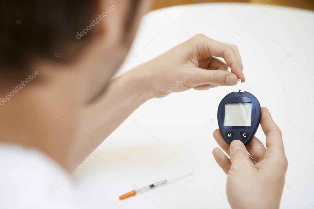 Man Using Blood Sugar Meter