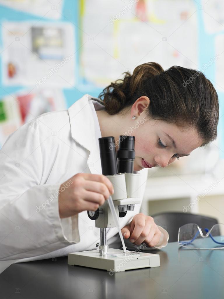High School female  Student  with microscope 