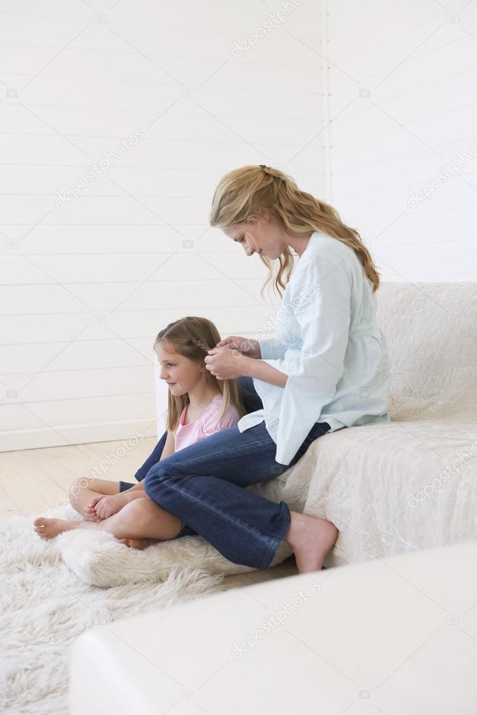 Woman Braiding Daughter Hair