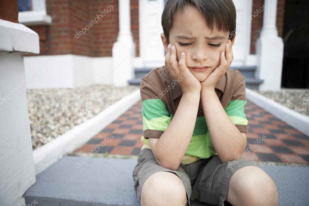 Sad boy sitting on steps