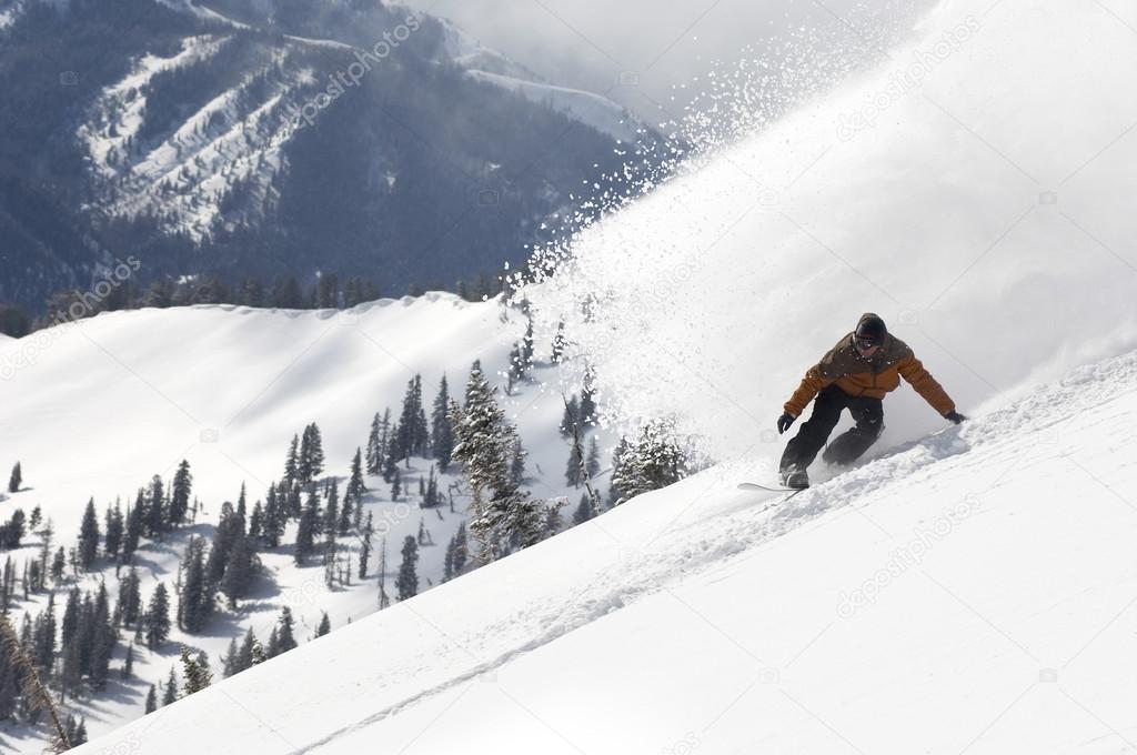 Man snowboarding down hill