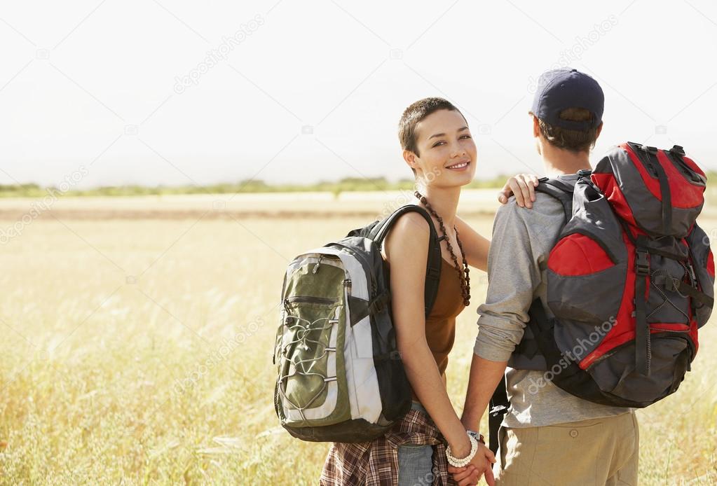Hiking couple standing in field
