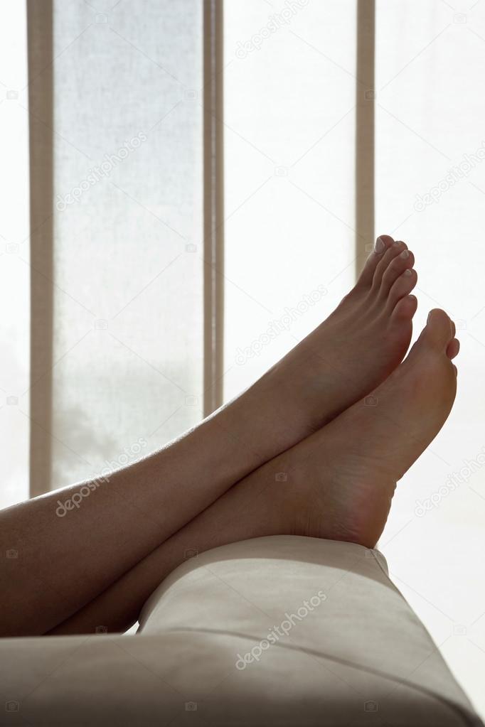 Woman resting with feet up on sofa