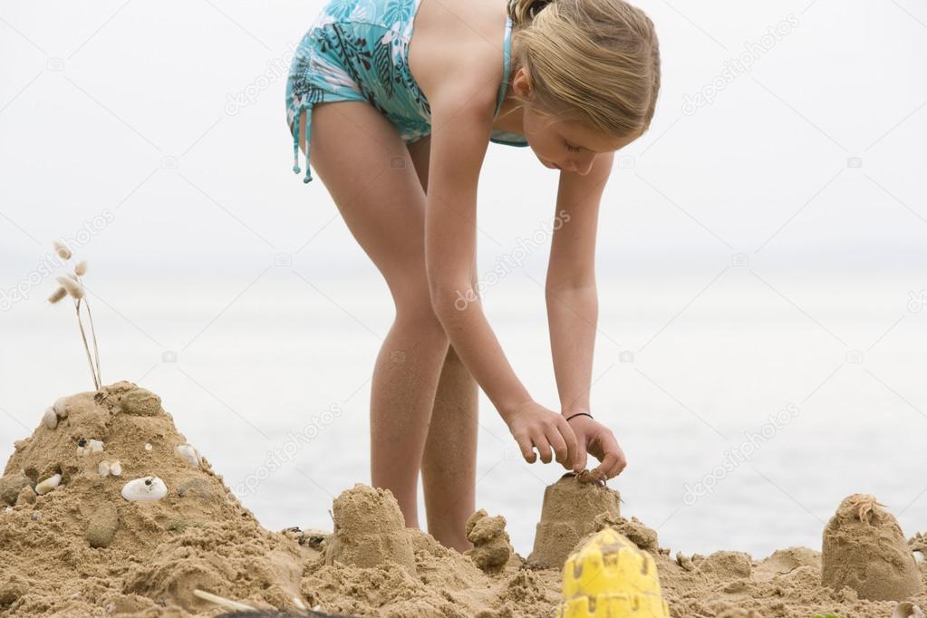 girl building sand castle 
