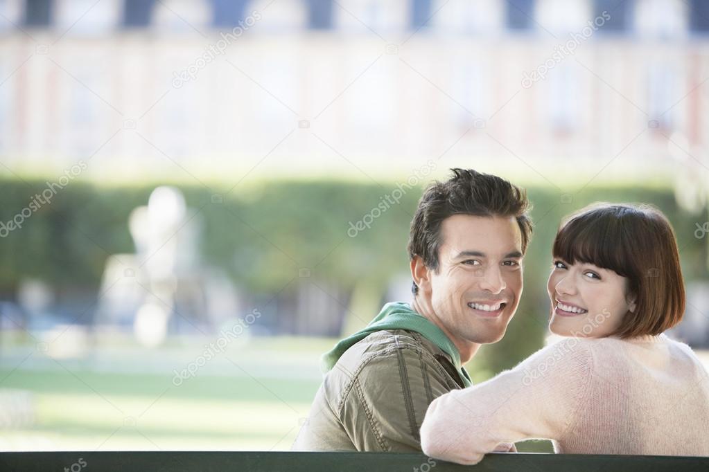 Couple sitting on bench in park