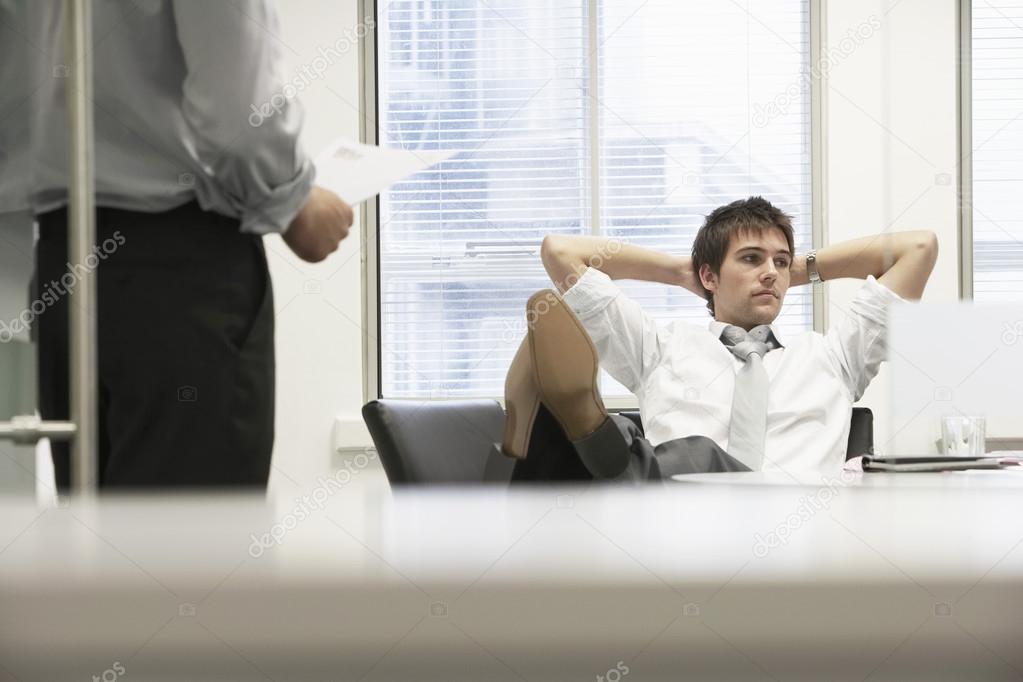 Disinterested businessman reclining on chair
