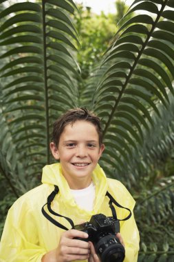 Boy with Camera exploring plants clipart
