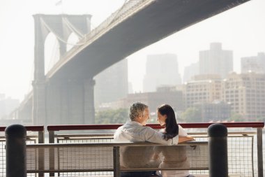 Çift rahatlatıcı brooklyn Köprüsü'nün altında bankta
