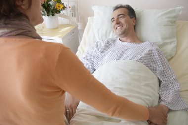Woman visiting man in hospital clipart