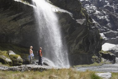 yürüyüşçüler şelale altında