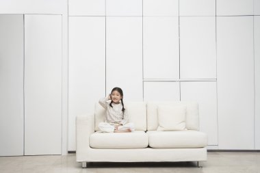 Girl sitting cross-legged Sofa clipart