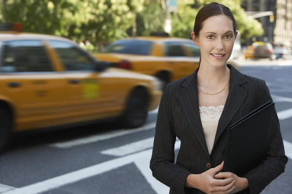Geschäftsfrau hält Portfolio in der Straße — Stockfoto